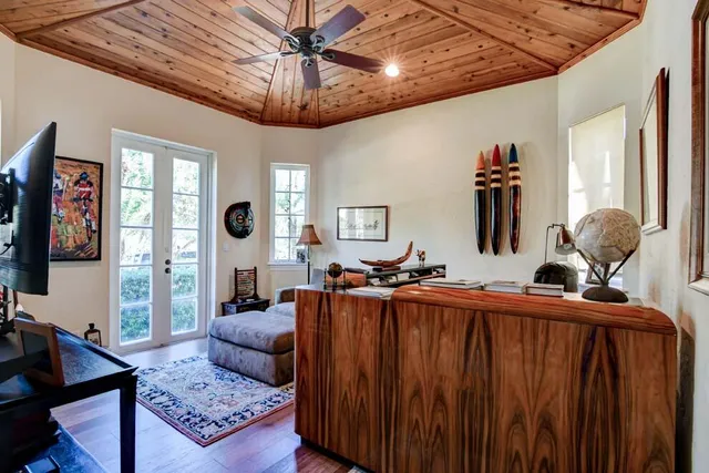 a living room with furniture a chandelier and a flat screen tv
