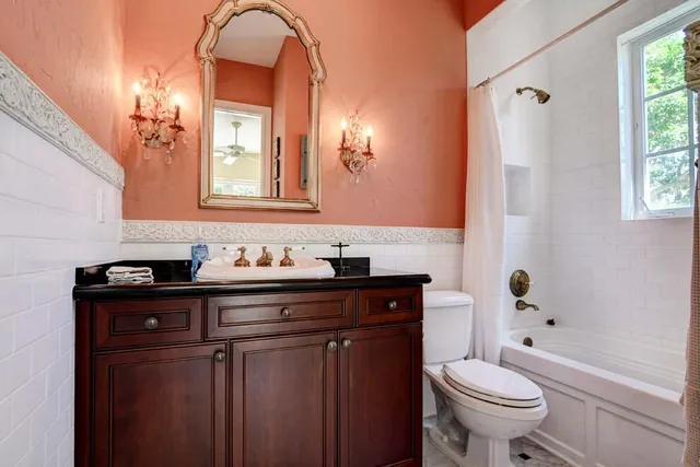 a bathroom with a granite countertop sink toilet and shower