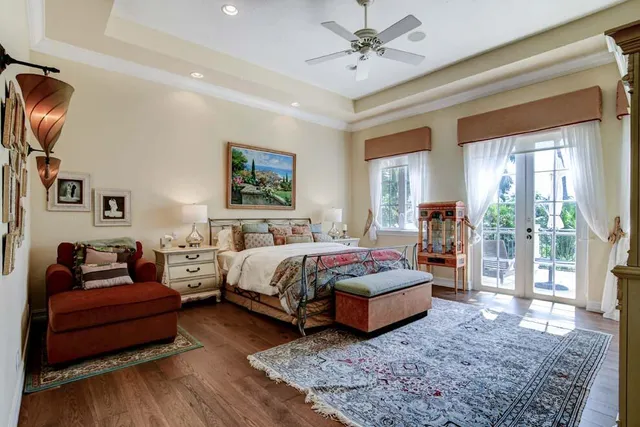 a spacious bedroom with a bed a couch and potted plant with the dresser