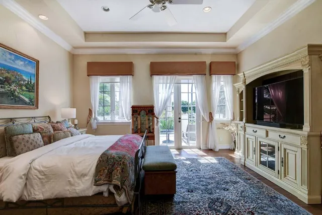 a bedroom with a bed a flat screen tv and a fireplace