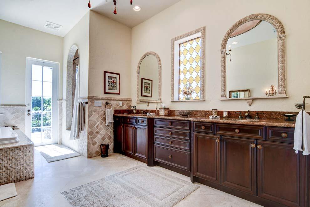1054 Melaleuca Road Delray Beach, FL 33483 - Photo 20 of 26 a spacious bathroom with a granite countertop sink and a mirror