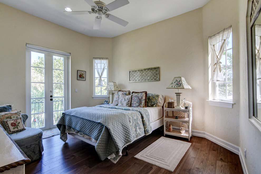 1054 Melaleuca Road Delray Beach, FL 33483 - Photo 22 of 26 a bedroom with a bed and a chandelier