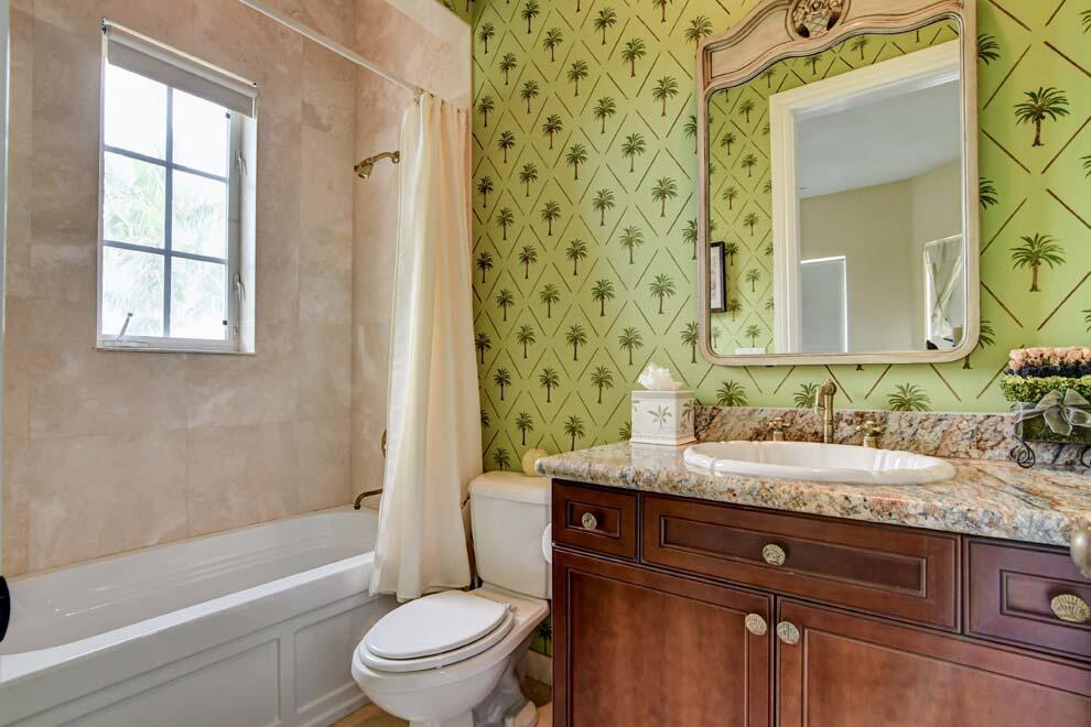 1054 Melaleuca Road Delray Beach, FL 33483 - Photo 23 of 26 a bathroom with a granite countertop toilet a sink a mirror a window and a bathtub