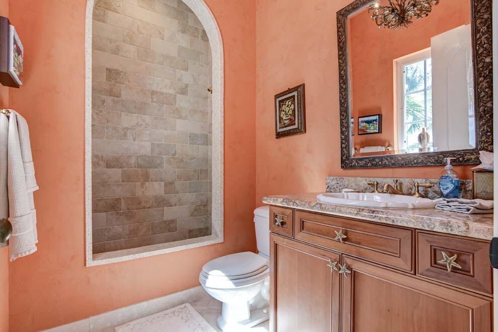 1054 Melaleuca Road Delray Beach, FL 33483 - Photo 25 of 26 a bathroom with a granite countertop toilet sink and mirror