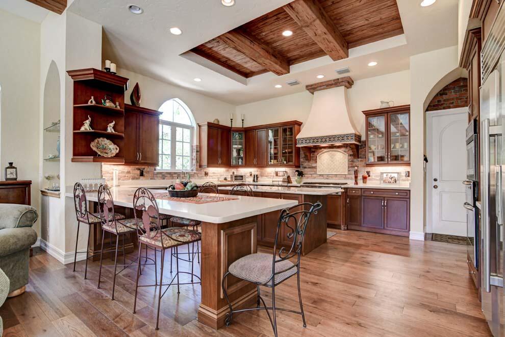 1054 Melaleuca Road Delray Beach, FL 33483 - Photo 9 of 26 a kitchen with stainless steel appliances granite countertop a table chairs and a refrigerator
