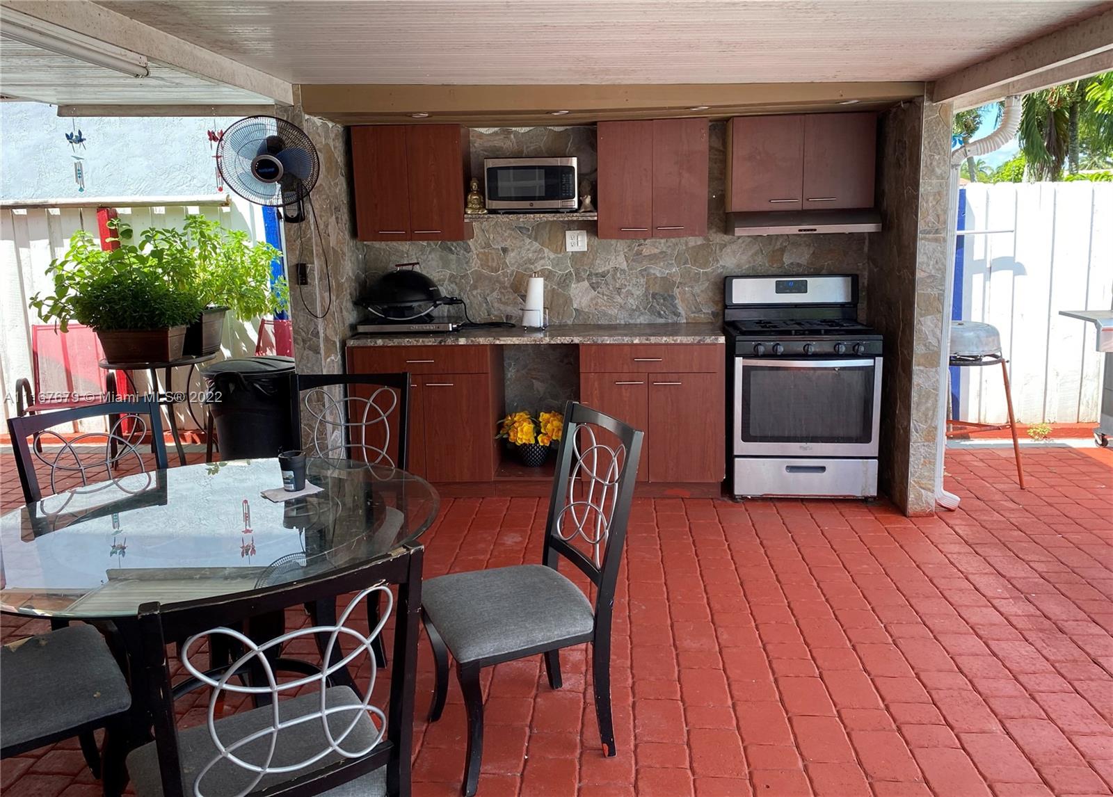 West Kendall Miami, FL 33193 - Photo 15 of 15 a kitchen with stainless steel appliances granite countertop a stove a refrigerator a microwave a dining table and chairs with wooden floor