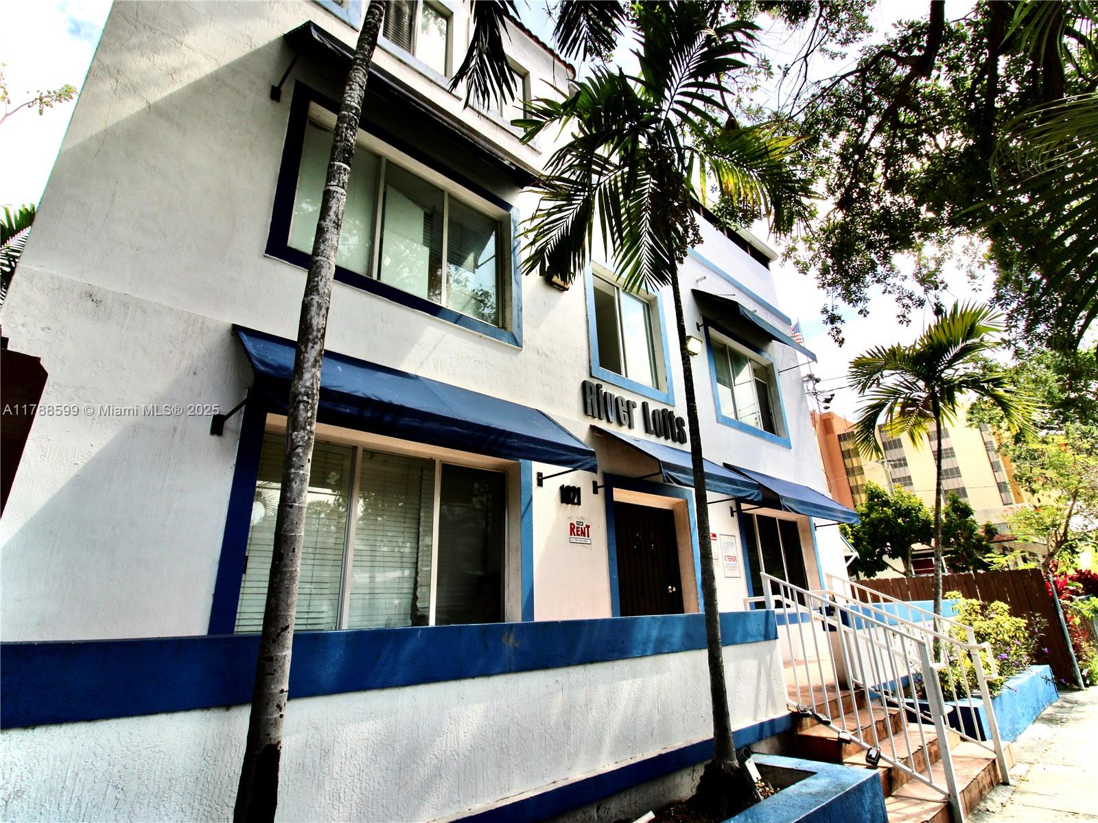 1021 Northwest 3rd Street, Unit 201 Miami, FL 33128 - Photo 1 of 27 a front view of a house with a tree