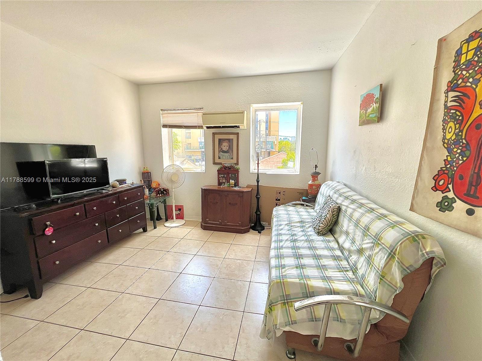 1021 Northwest 3rd Street, Unit 201 Miami, FL 33128 - Photo 11 of 27 a living room with furniture and a flat screen tv