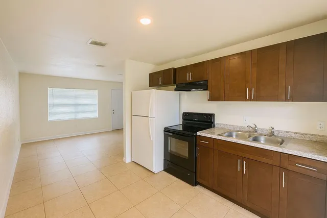 a kitchen with a sink a refrigerator and cabinets