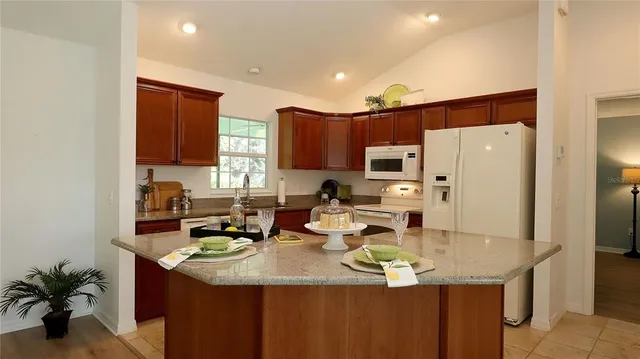 a kitchen with stainless steel appliances granite countertop a sink refrigerator and cabinets