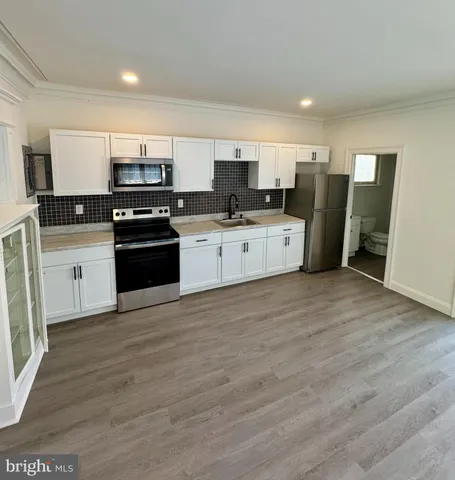 a kitchen with stainless steel appliances a refrigerator sink and stove