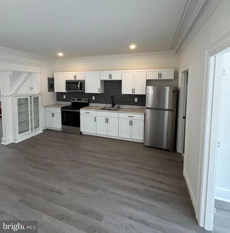 a kitchen with stainless steel appliances a refrigerator and a stove top oven