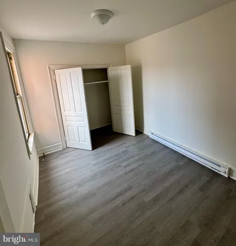 an empty room with wooden floor and door