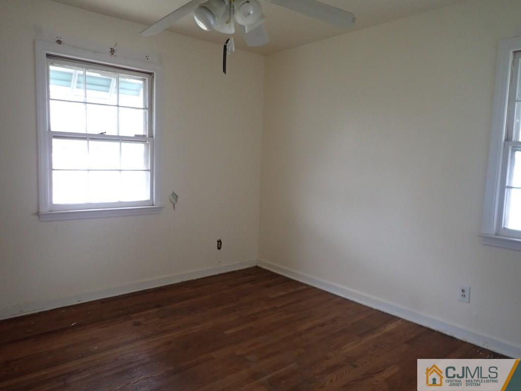 25 Hull Drive Edison, NJ 08817 - Photo 5 of 11 an empty room with wooden floor and windows
