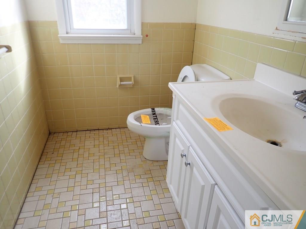 25 Hull Drive Edison, NJ 08817 - Photo 10 of 11 a bathroom with a sink a toilet and a mirror