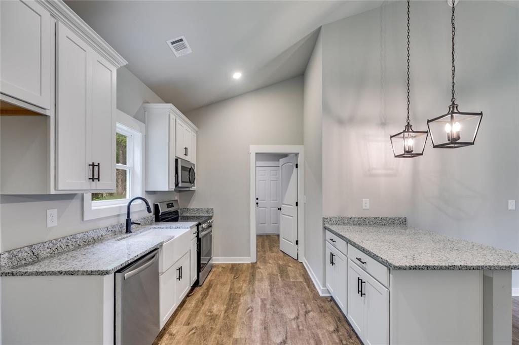 342 Dandy Road Dallas, GA 30132 - Photo 23 of 35 a kitchen with granite countertop a sink stove and cabinets