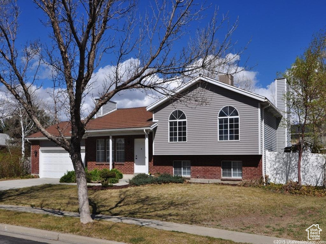 11849 Hagan Road Sandy, UT 84092 - Photo 1 of 1 Split level home featuring a chimney, a garage, a front lawn, and brick siding