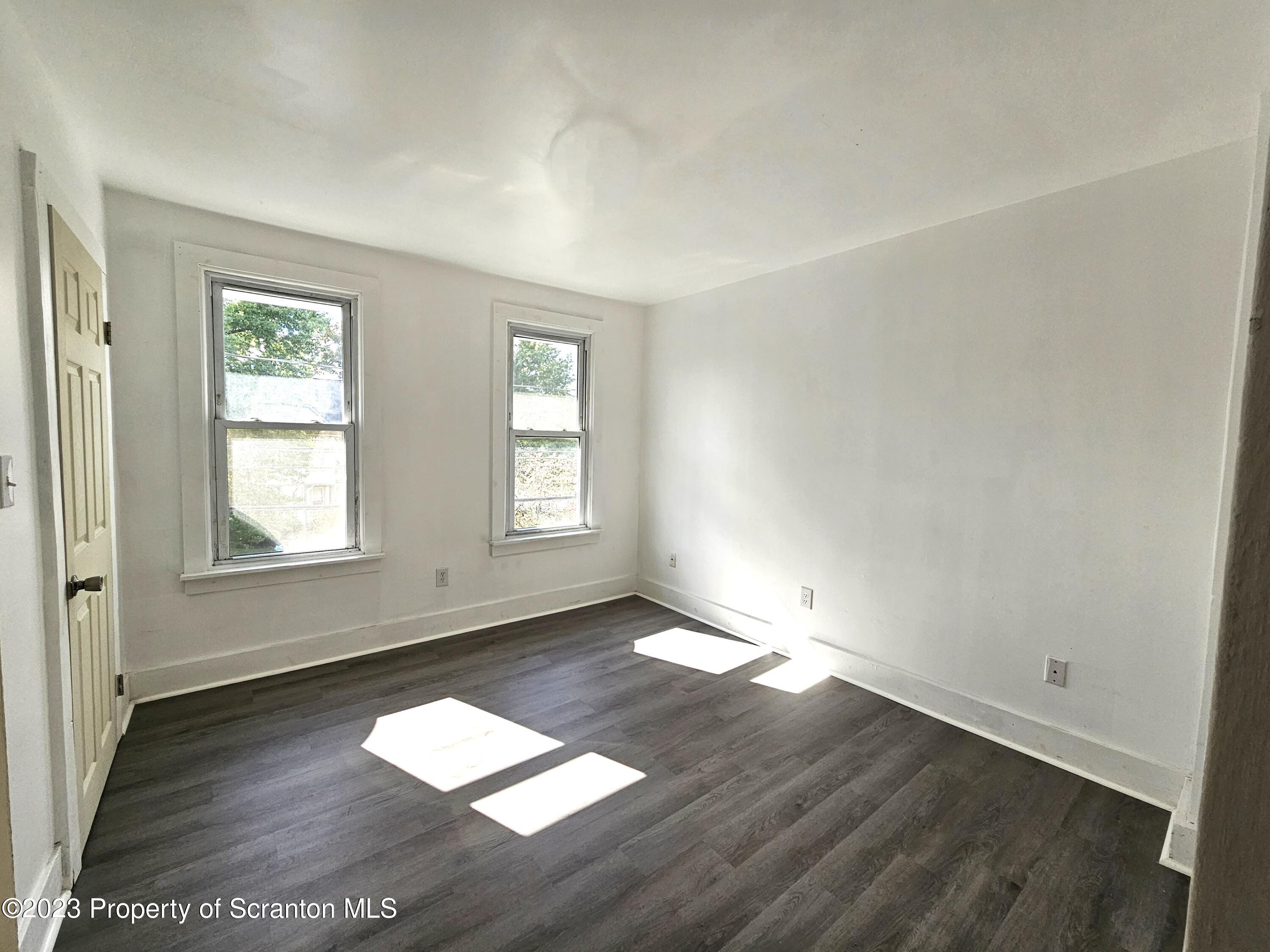 905 Green Ridge Street Scranton, PA 18509 - Photo 3 of 11 an empty room with wooden floor and windows