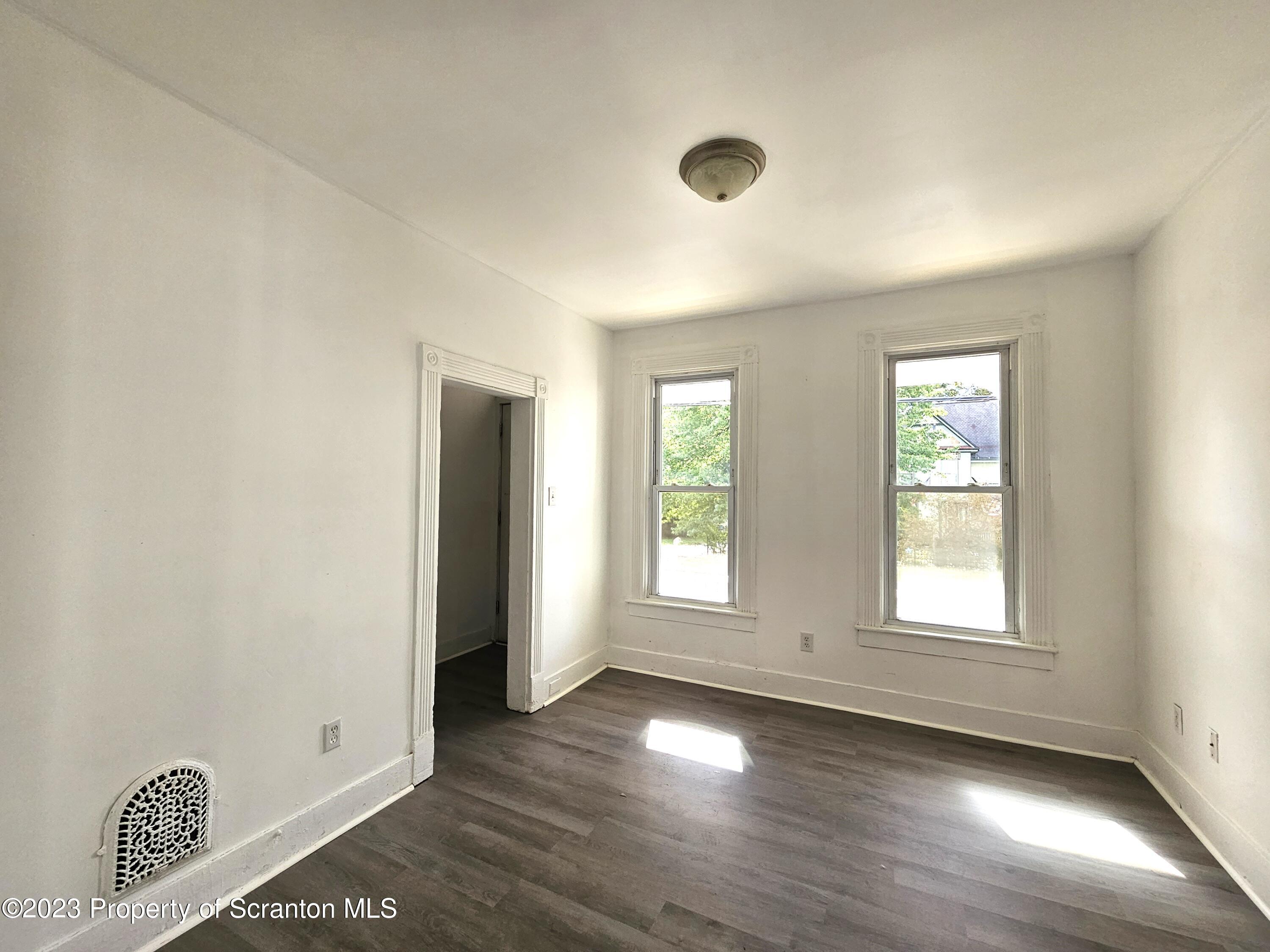 905 Green Ridge Street Scranton, PA 18509 - Photo 4 of 11 a view of an empty room with wooden floor and a window