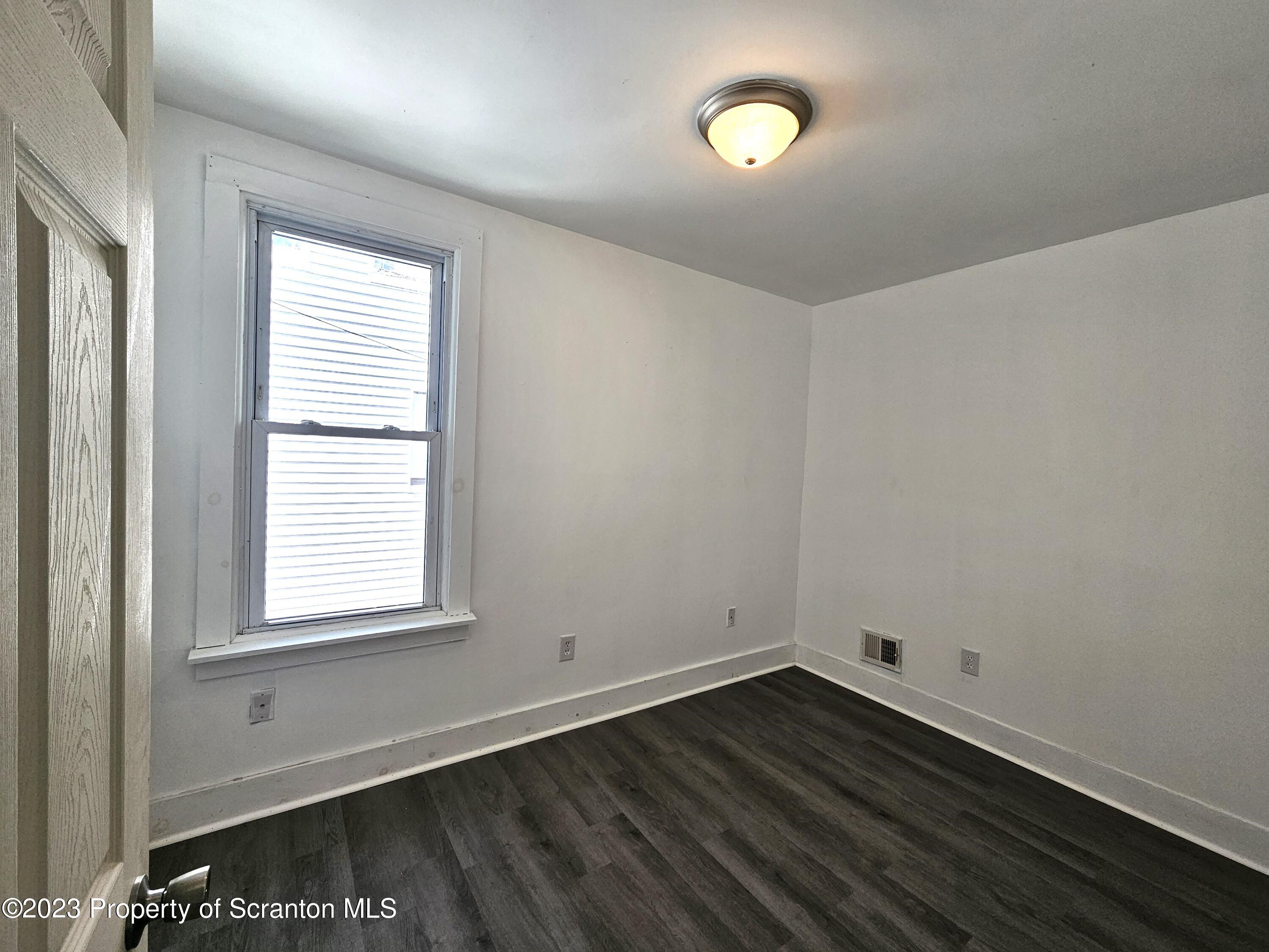 905 Green Ridge Street Scranton, PA 18509 - Photo 6 of 11 an empty room with wooden floor and windows