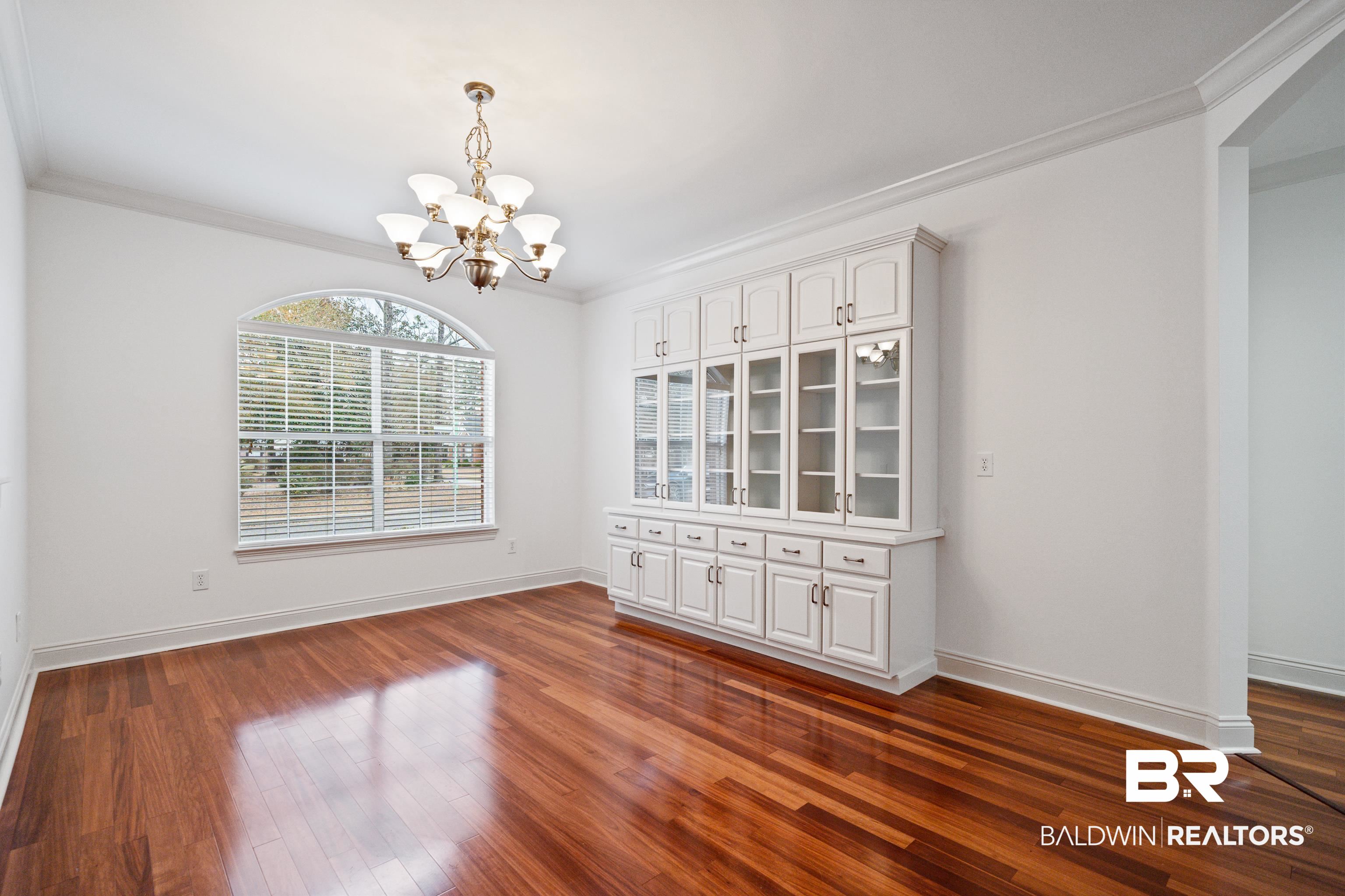 404 Savannah Lane Foley, AL 36535 - Photo 6 of 29 Unfurnished room with dark wood-type flooring, crown molding, baseboards, and an inviting chandelier