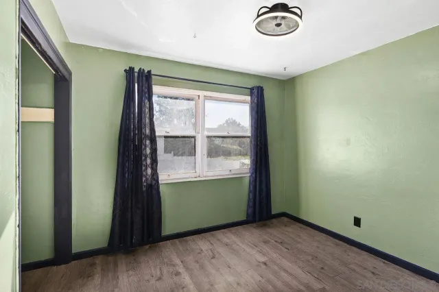 an empty room with window wooden floor and windows