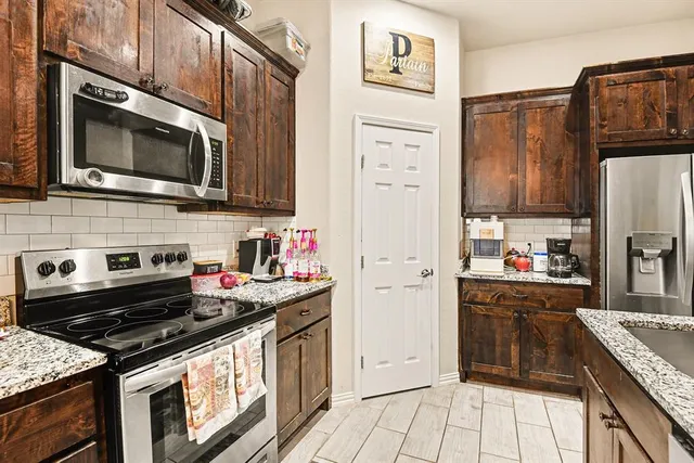 a kitchen with stainless steel appliances a stove a microwave and cabinets