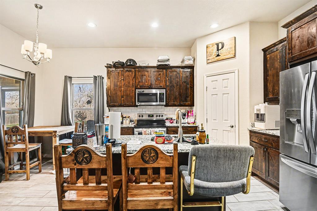 621 North Ave B Springtown, TX 76082 - Photo 16 of 28 a living room with furniture a flat screen tv and kitchen view