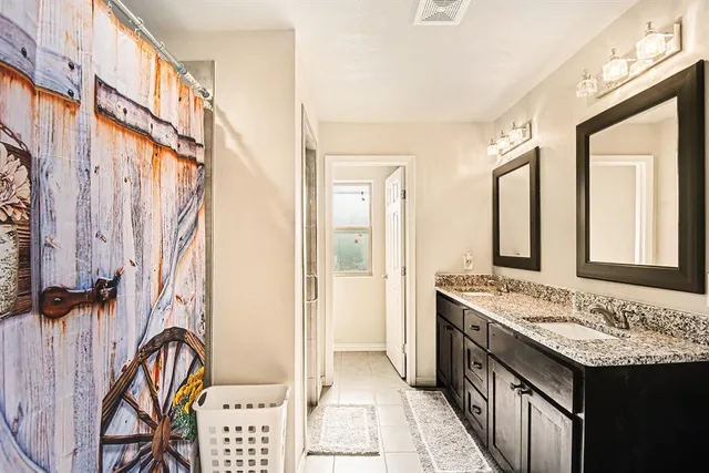a bathroom with a granite countertop sink and a mirror