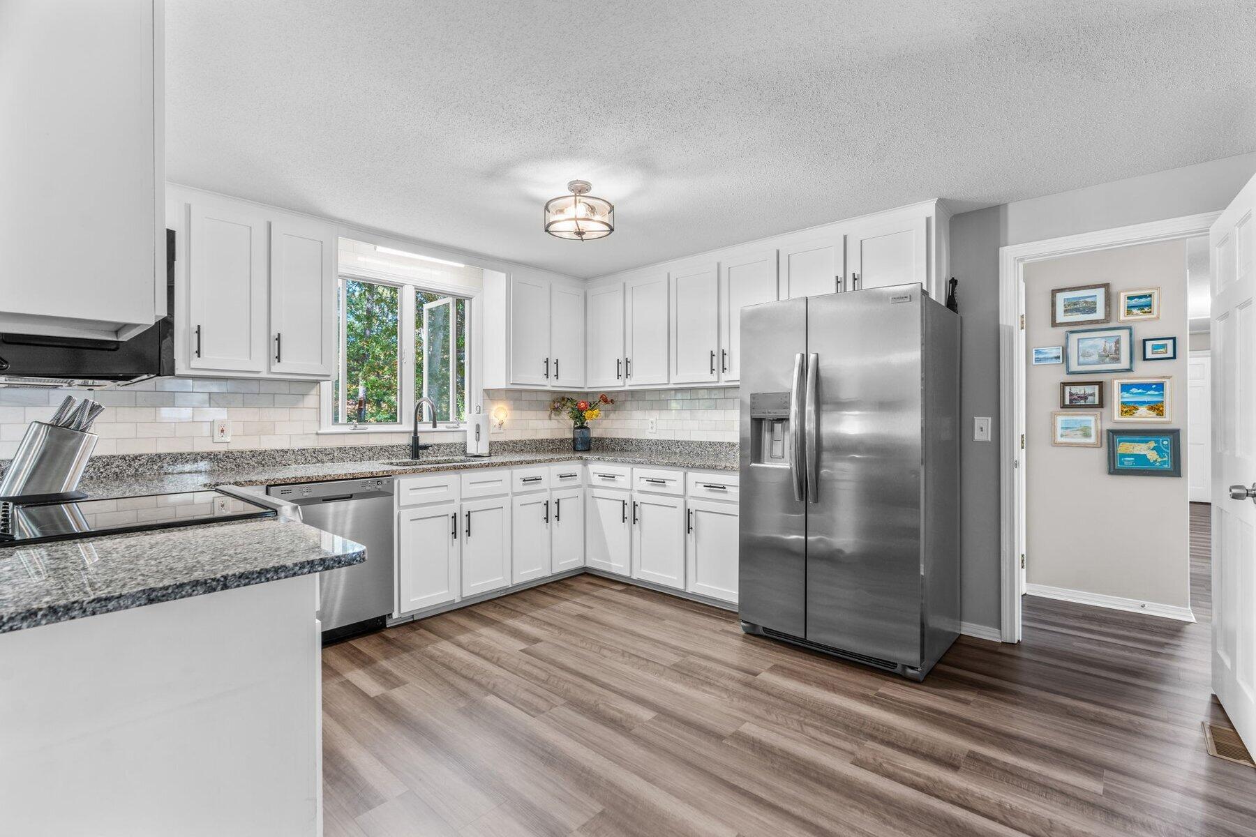 315 Prince Hinckley Road Centerville, MA 02632 - Photo 13 of 39 a kitchen with stainless steel appliances granite countertop a refrigerator a sink dishwasher a stove top oven a refrigerator and white cabinets