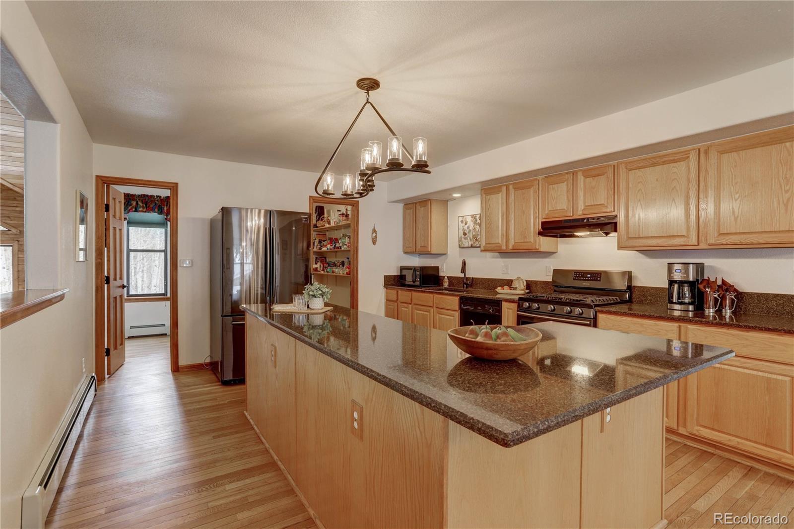 105 Desperado Road Bailey, CO 80421 - Photo 13 of 40 a kitchen with granite countertop a sink counter top space appliances and cabinets