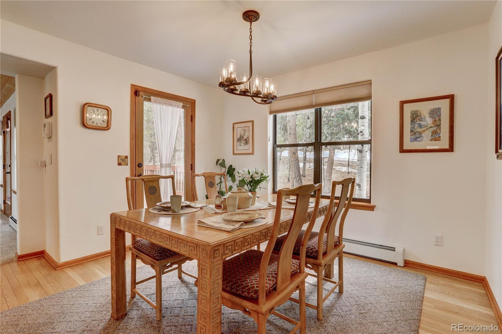 105 Desperado Road Bailey, CO 80421 - Photo 16 of 40 a view of a dining room with furniture window and wooden floor
