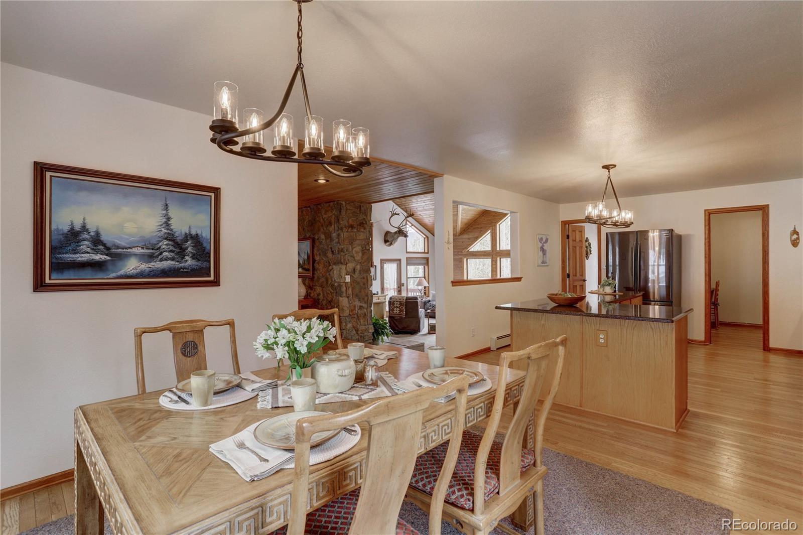 105 Desperado Road Bailey, CO 80421 - Photo 17 of 40 a view of a dining room with furniture a chandelier and wooden floor