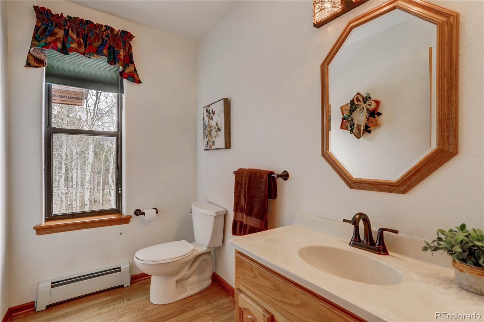 105 Desperado Road Bailey, CO 80421 - Photo 24 of 40 a bathroom with a toilet sink and mirror