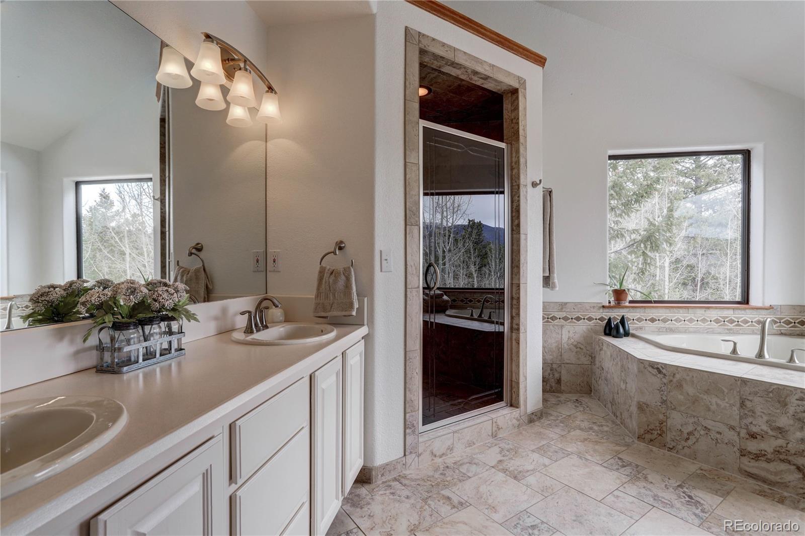 105 Desperado Road Bailey, CO 80421 - Photo 28 of 40 a spacious bathroom with a tub sink and mirror