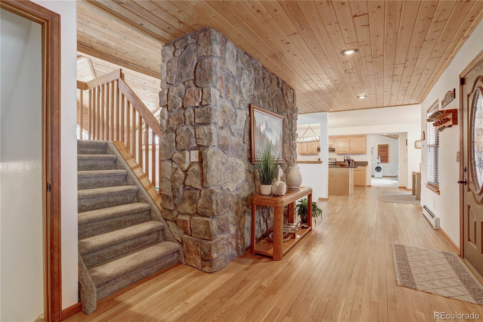 105 Desperado Road Bailey, CO 80421 - Photo 6 of 40 a view of a hallway with wooden floor and staircase