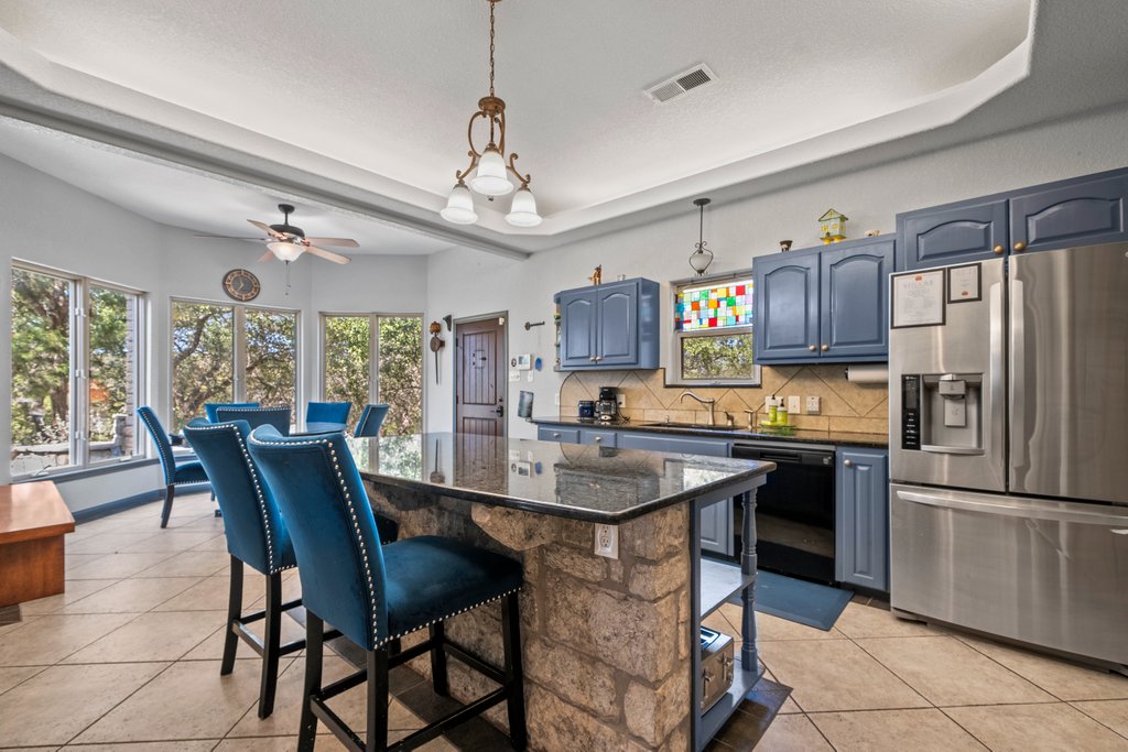 209 Lakeview Circle Spring Branch, TX 78070 - Photo 11 of 40 Kitchen with black dishwasher, stainless steel refrigerator with ice dispenser, visible vents, backsplash, and a kitchen bar