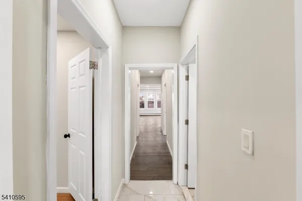 a view of a hallway with wooden floor and closet