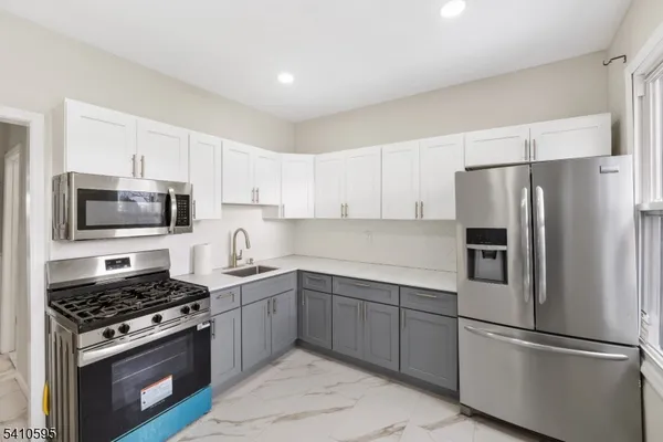 a kitchen with stainless steel appliances a refrigerator stove and microwave
