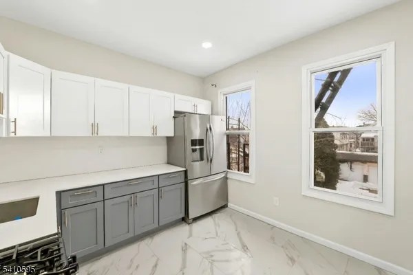 a kitchen with stainless steel appliances granite countertop a refrigerator and a stove top oven