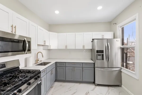 a kitchen with stainless steel appliances granite countertop a stove a refrigerator and a sink
