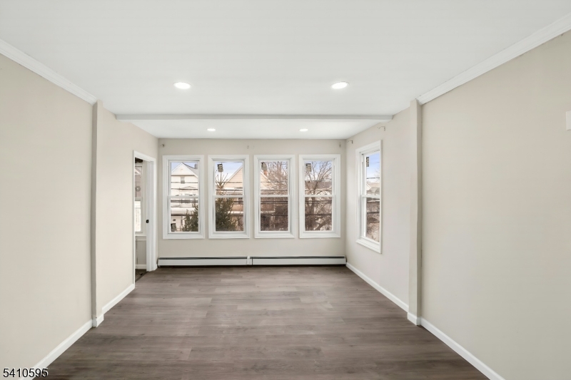 335 Boulevard Passaic, NJ 07055 - Photo 7 of 35 an empty room with wooden floor and windows