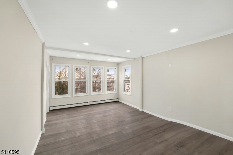 335 Boulevard Passaic, NJ 07055 - Photo 9 of 35 an empty room with wooden floor and windows