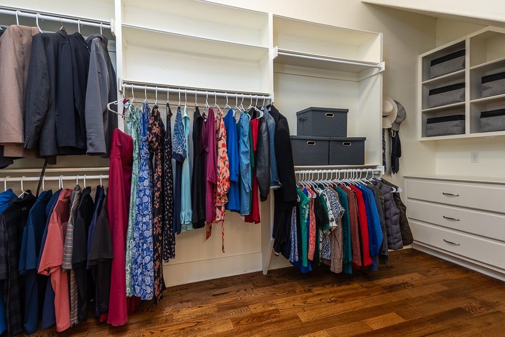 328 Washington Street Collierville, TN 38017 - Photo 17 of 33 Custom closet system featuring wood-finish flooring, multiple hanging rods, open shelving, and built-in drawers