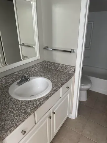 a bathroom with a granite countertop sink and a mirror