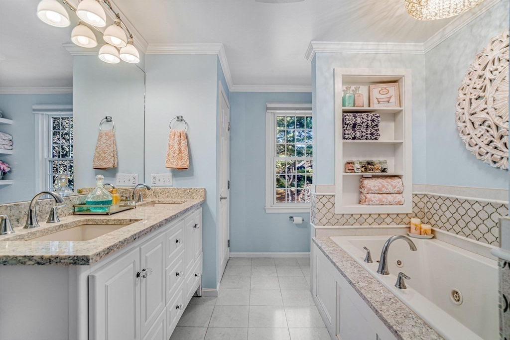 14 Hawthorne Village, Unit D Franklin, MA 02038 - Photo 28 of 42 a bathroom with a granite countertop tub a sink and a large mirror