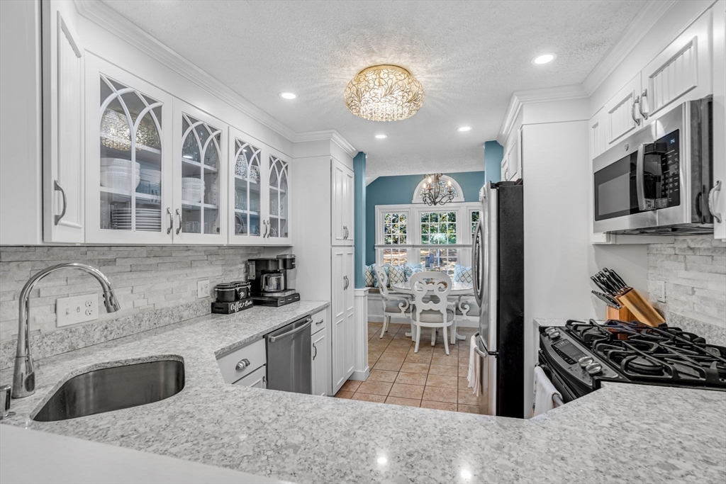 14 Hawthorne Village, Unit D Franklin, MA 02038 - Photo 9 of 42 a kitchen with stainless steel appliances granite countertop a sink stove and refrigerator