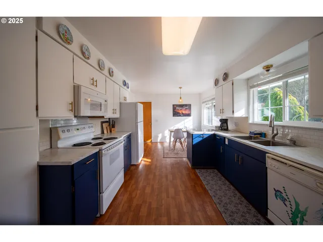 a large kitchen with stainless steel appliances granite countertop a lot of counter space and wooden floors