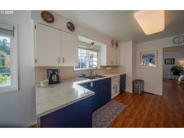 a kitchen with kitchen island granite countertop a sink cabinets and wooden floor