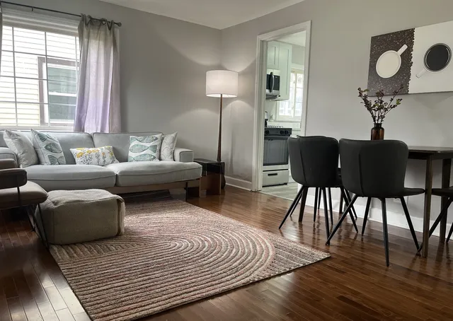 a living room with furniture and a wooden floor